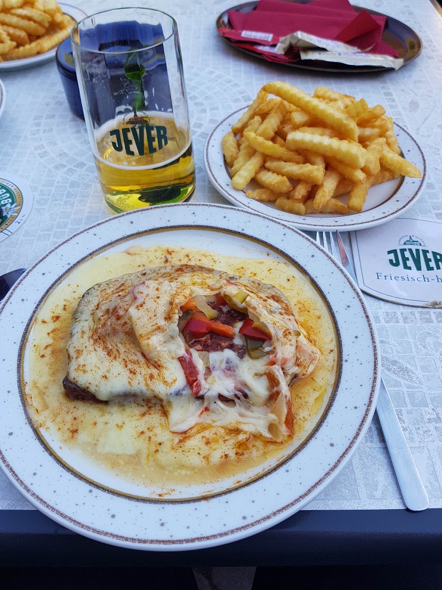 Gericht mit Pommes und einem Glas Jever im Biergarten